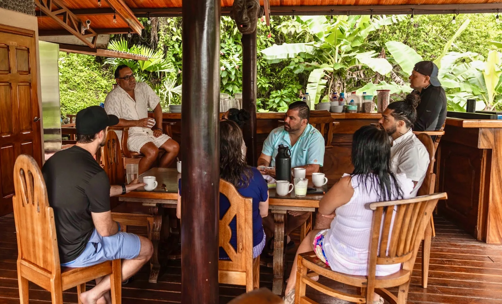 Mastermind retreat group meeting around the table on the deck at The Majestic Lodge, La Fortuna