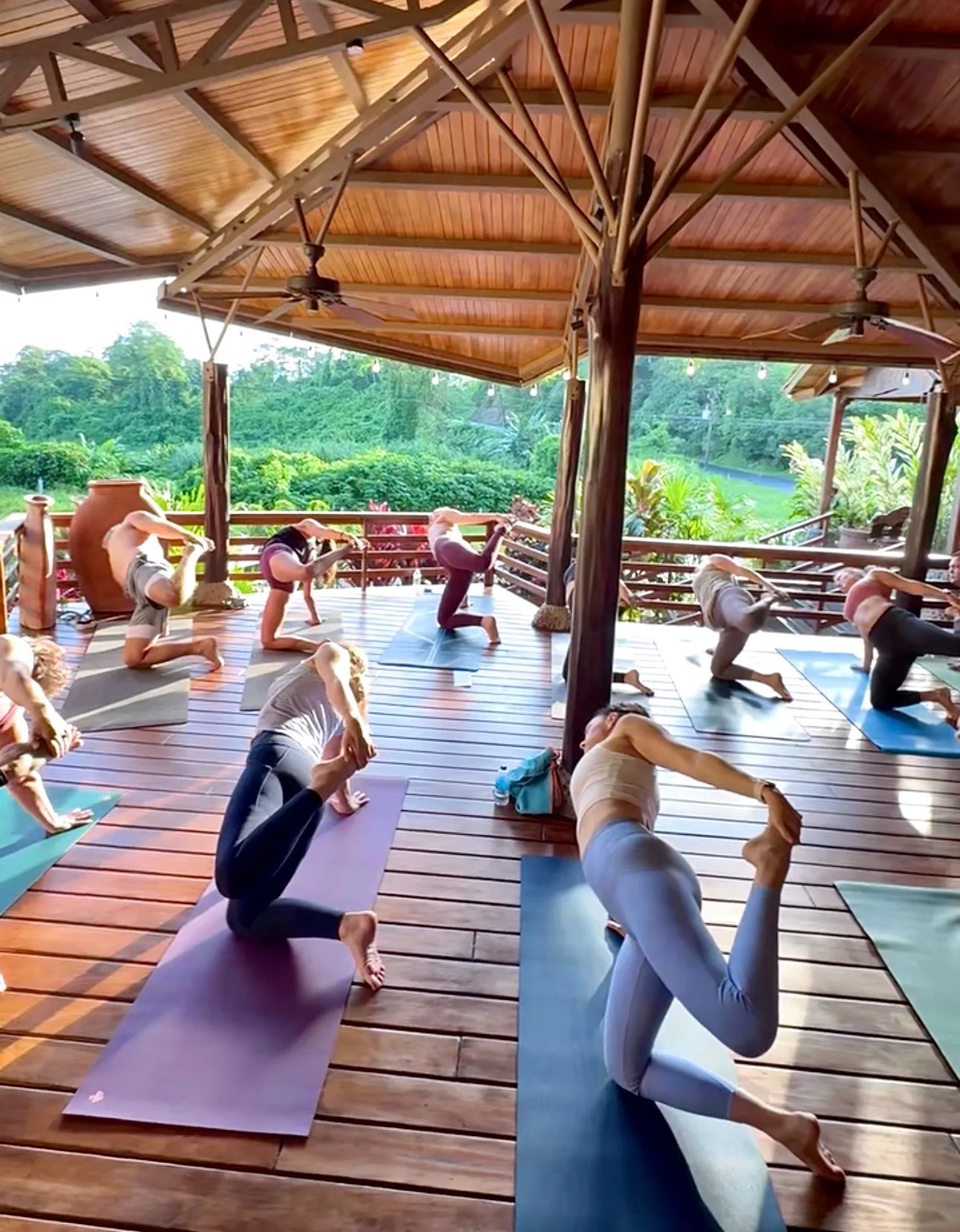 Yoga retreat group practicing on the covered deck of The Majestic Lodge, a rainforest retreat venue in La Fortuna, Costa Rica